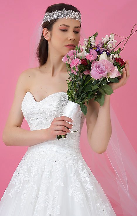 Diseño de vestido de novia con escote en forma de corazón con encaje en todo el talle con un sutil bordado en cristal, la falda con encaje y una cenefa.